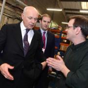Databac production manager David Gaskin shows Iain Duncan Smith and James Berry around the factory