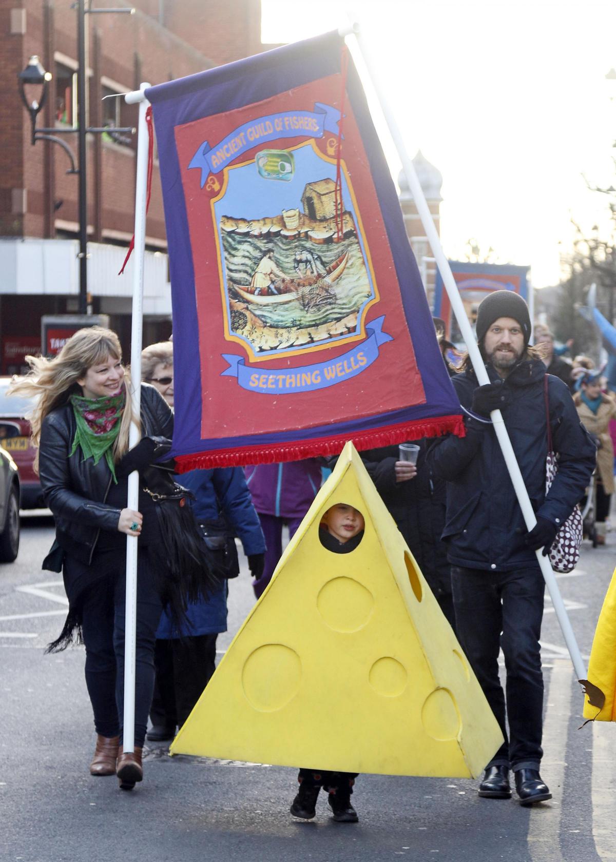 A wedge of cheese marches proudly under the banner of the Seething Wells Guild of Fishers