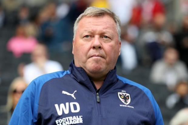Wimbledon manager Wally Downes has been suspended after being charged with betting offences