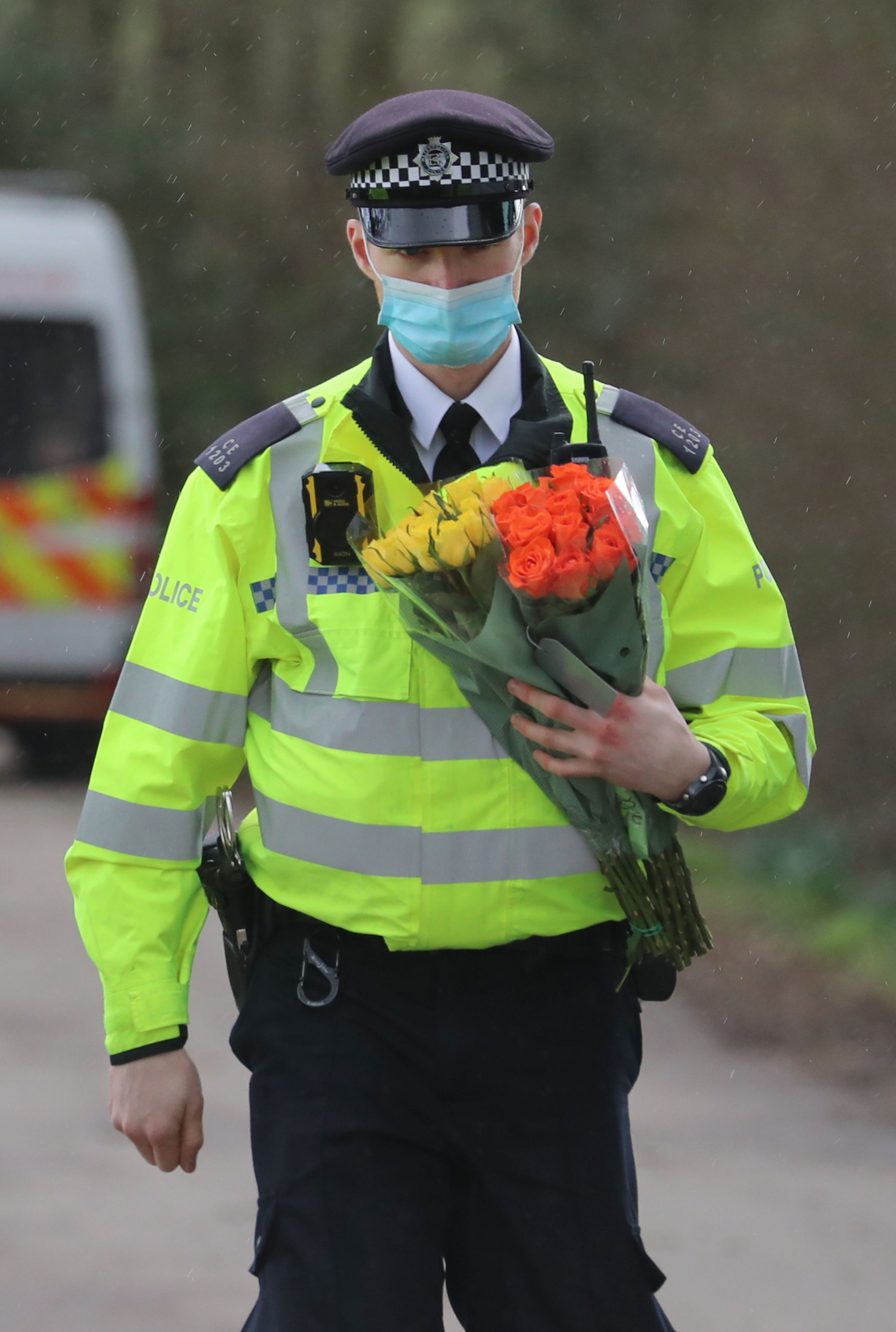 A police officer carries flowers from members of the public at Great Chart Golf and Leisure near Ashford in Kent following the discovery of human remains in the hunt for missing Sarah Everard. Gareth Fuller/PA Wire