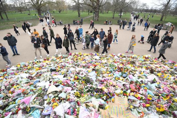 Surrey Comet: People viewing floral tributes left at the bandstand in Clapham Common, London, for Sarah Everard