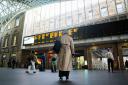 Passengers look at the departure board at Kings Cross station in London (PA)