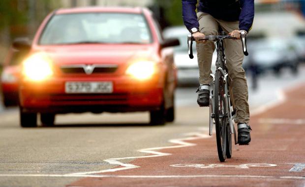 Surrey Comet: Photo via PA shows a cyclist on the road near traffic.