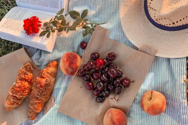Surrey Comet: Various summery items on a picnic blanket. Credit: Canva