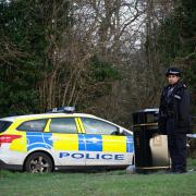 Police at Gravelly Hill in Caterham, Surrey, where a dog attacked members of the public on Thursday. A woman in her 20s was pronounced dead at the scene